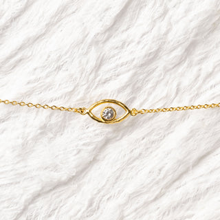detail of Gold bracelet with evil eye and white topaz