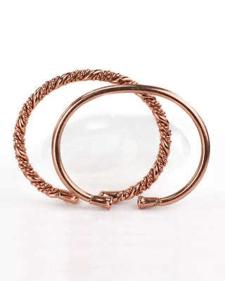 twee koperen armbanden